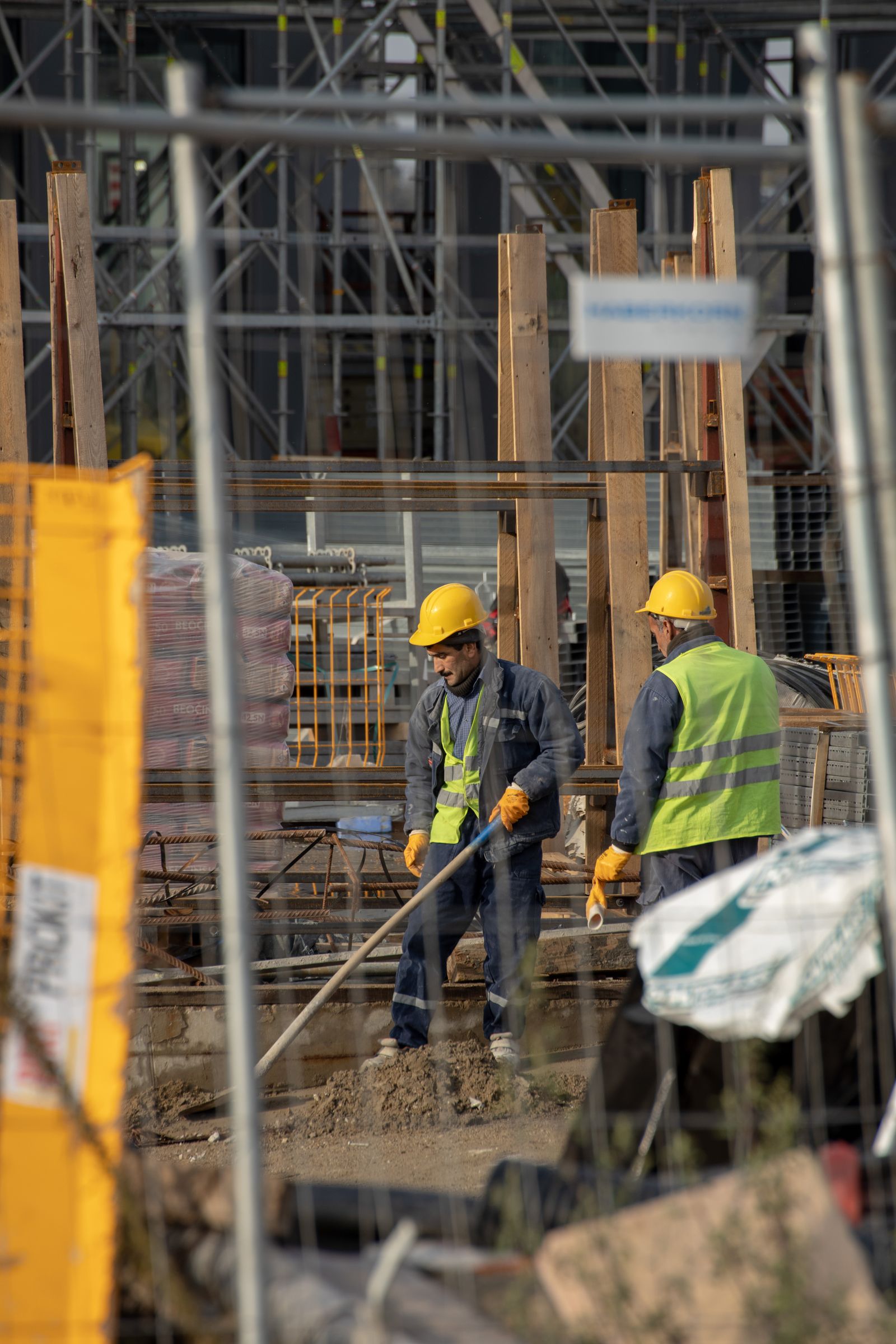 Construction workers in helmets and reflective vests on a building site