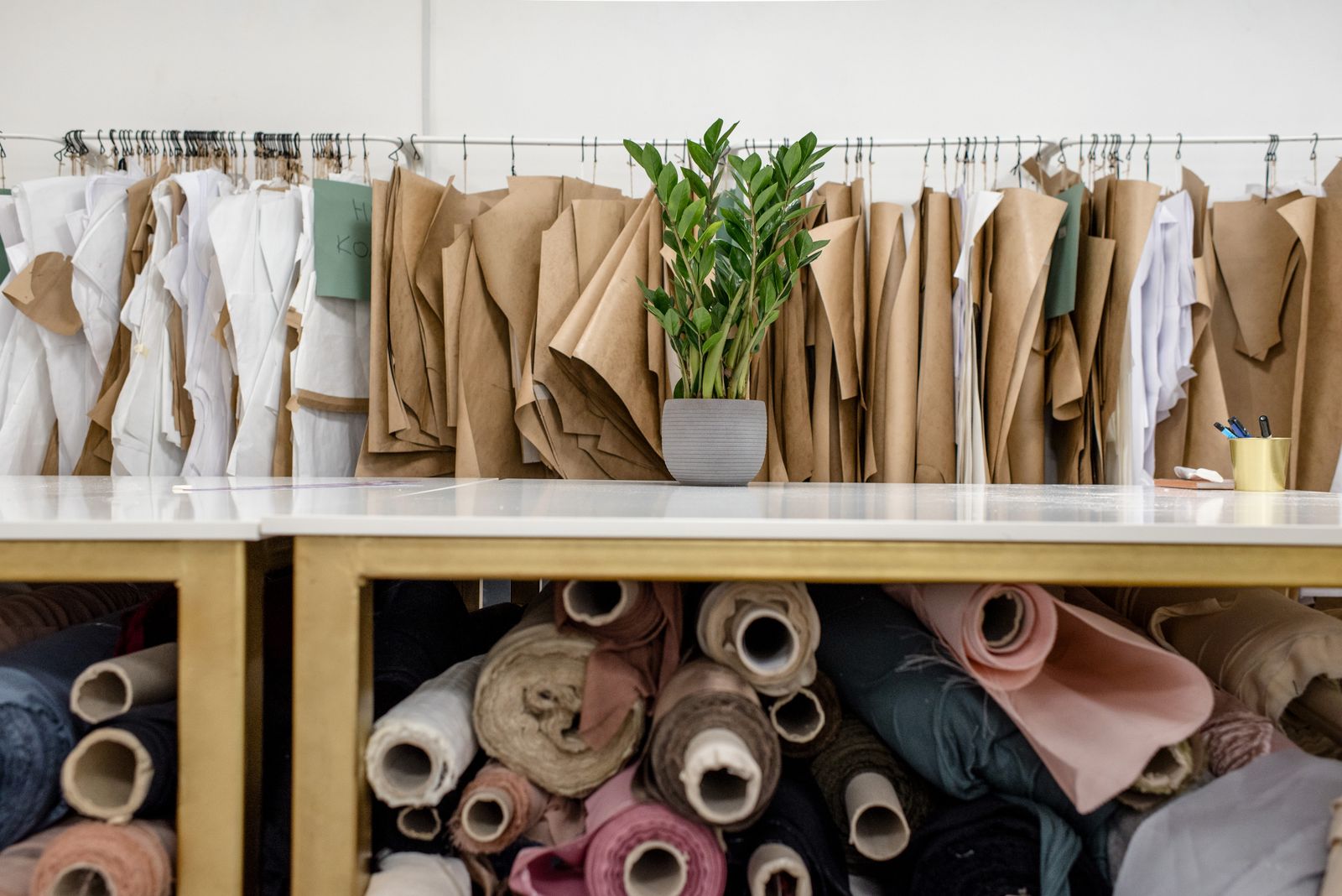 Rolls of assorted fabrics and sewing patterns inside a tailoring atelier