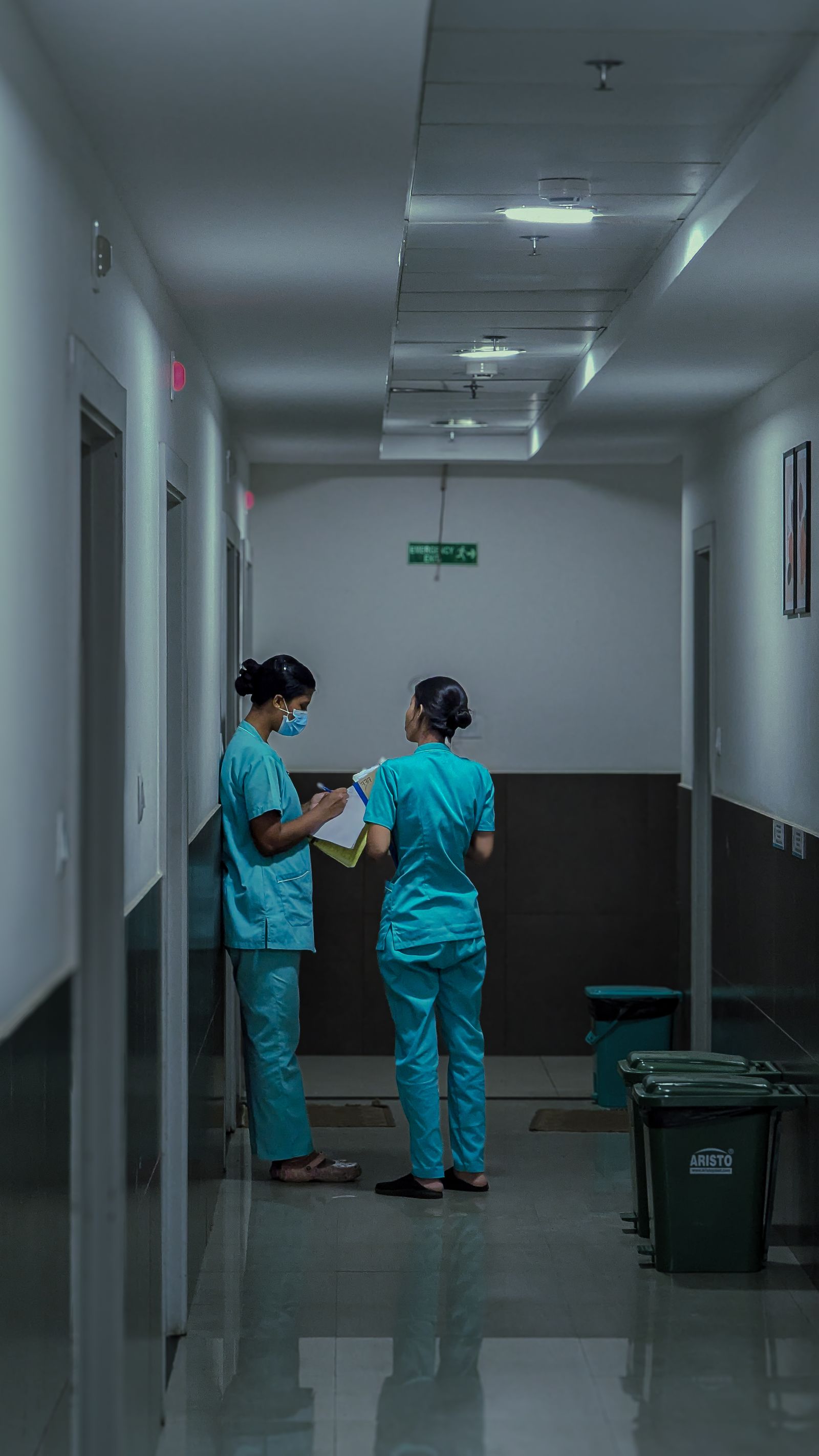 Healthcare workers in scrubs walking through a hospital corridor