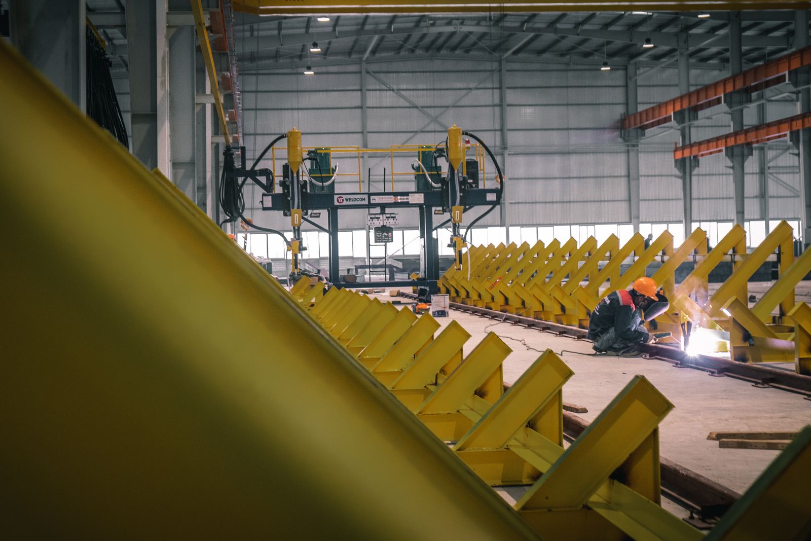 Welder in protective gear working in an industrial facility